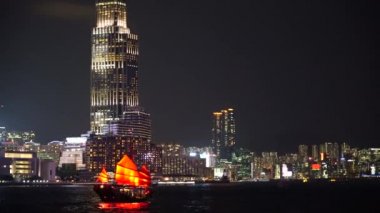 Hong Kong City gece görünümü kırmızı yelken önemsiz tekneler ile. 