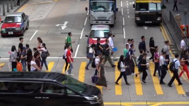Hong Kong, Çin, 17 Nisan 2019: Hong Kong des Voeux Road Central District meşgul sokakları ve Zebra üzerinde yürüyen yayalar yavaş hareket.