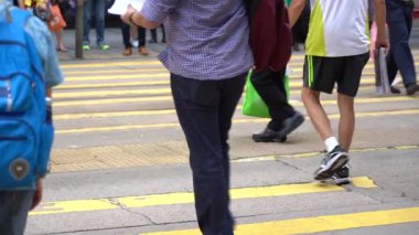 Hong Kong, Çin, 17 Nisan 2019: Hong Kong des Voeux Road Central District meşgul sokakları ve Zebra üzerinde yürüyen yayalar yavaş hareket.