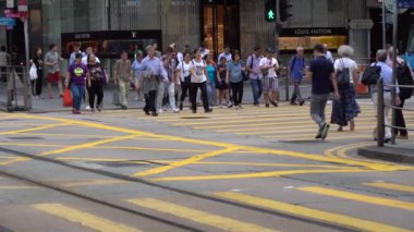 Hong Kong, Çin, 17 Nisan 2019: Hong Kong des Voeux Road Central District meşgul sokakları ve Zebra üzerinde yürüyen yayalar yavaş hareket.