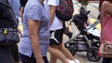 Hong Kong, Çin, 17 Nisan 2019: Hong Kong des Voeux Road Central District meşgul sokakları ve Zebra üzerinde yürüyen yayalar yavaş hareket.