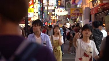 Osaka, Japonya, 17 Haziran 2019 : Gece Dotonbori'yi ziyaret eden turistlerin yavaş hareketi. Dotonbori, Japonya'nın Osaka bölgesinin en popüler seyahat sitesidir.