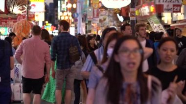 Osaka, Japonya, 17 Haziran 2019 : Gece Dotonbori'yi ziyaret eden turistlerin yavaş hareketi. Dotonbori, Japonya'nın Osaka bölgesinin en popüler seyahat sitesidir.