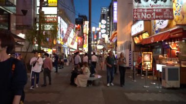 Osaka, Japonya, 17 Haziran 2019 : Gece Dotonbori'yi ziyaret eden turistlerin yavaş hareketi. Dotonbori, Japonya'nın Osaka bölgesinin en popüler seyahat sitesidir.