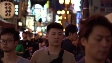 Osaka, Japonya, 17 Haziran 2019 : Gece Dotonbori'yi ziyaret eden turistlerin yavaş hareketi. Dotonbori, Japonya'nın Osaka bölgesinin en popüler seyahat sitesidir.