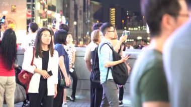 Osaka, Japonya, 17 Haziran 2019 : Gece Dotonbori'yi ziyaret eden turistlerin yavaş hareketi. Dotonbori, Japonya'nın Osaka bölgesinin en popüler seyahat sitesidir.
