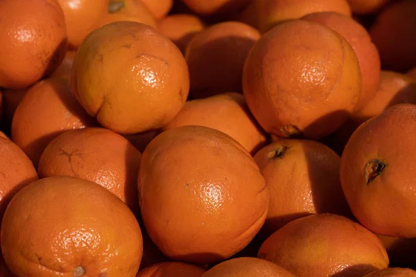 Fresh orange close up at market place; orange background