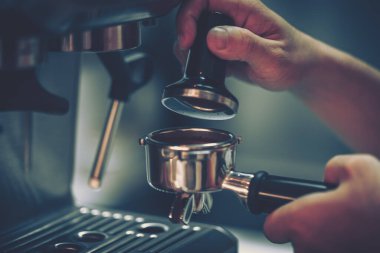 Barista kahve makinesi kullanıyor, yakın plan. 