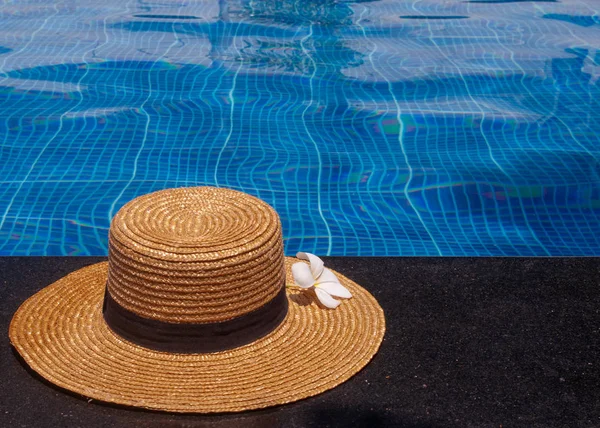 Flor y sombrero exóticos frangipani al lado de la piscina Imagen De Stock