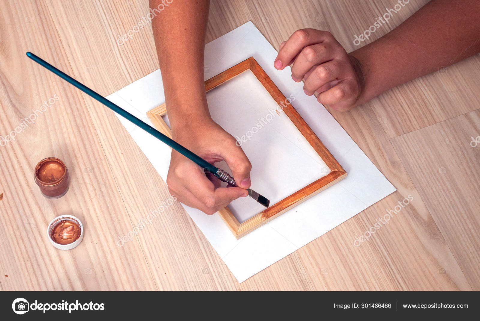 Hand With Brush Paint Wooden Door Frame In Bronze Color Top