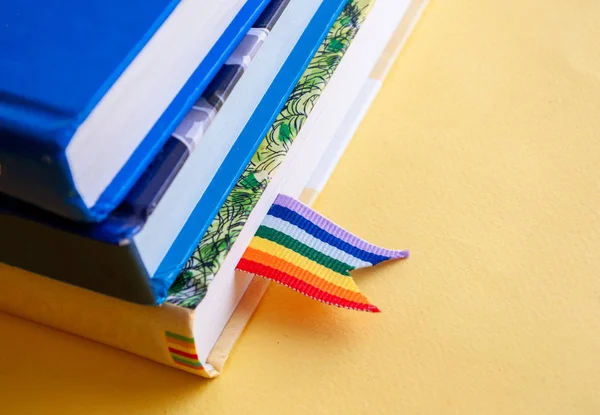 Una pila de tres libros con marcadores de cinta de arco iris está sobre la mesa. Concepto de regreso a la escuela, libertad, independencia, orgullo Fotos De Stock Sin Royalties Gratis