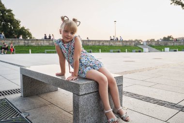 Taş bir bankta oturan kız          