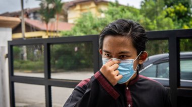 Coronavirus 'taki bayram kutlamasında geleneksel Kurta gömlekli Asyalı genç bir adamın portresi. Üç katlı yüz maskesi takıyor. Hijyen yaşam tarzı. Yeni normal kavram.