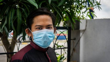 Coronavirus 'taki bayram kutlamasında geleneksel Kurta gömlekli Asyalı genç bir adamın portresi. Üç katlı yüz maskesi takıyor. Hijyen yaşam tarzı. Yeni normal kavram.