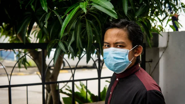 Coronavirus 'taki bayram kutlamasında geleneksel Kurta gömlekli Asyalı genç bir adamın portresi. Üç katlı yüz maskesi takıyor. Hijyen yaşam tarzı. Yeni normal kavram.