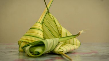 Pişmemiş Malay yemeği Ketupat Daun Palas ya da glüten pirincin fan palmiyesi yaprakları kullanılarak üçgen şeklinde sarıldığı pirinç köftesi. Genellikle Mübarek bayramında ya da Hari Raya kutlamalarında bulunur..