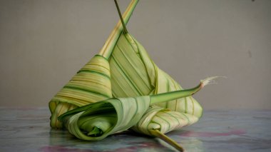 Pişmemiş Malay yemeği Ketupat Daun Palas ya da glüten pirincin fan palmiyesi yaprakları kullanılarak üçgen şeklinde sarıldığı pirinç köftesi. Genellikle Mübarek bayramında ya da Hari Raya kutlamalarında bulunur..