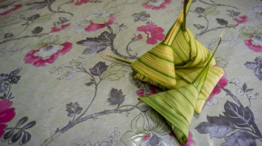 Pişmemiş Malay yemeği Ketupat Daun Palas ya da glüten pirincin fan palmiyesi yaprakları kullanılarak üçgen şeklinde sarıldığı pirinç köftesi. Genellikle Mübarek bayramında ya da Hari Raya kutlamalarında bulunur..