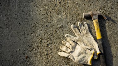 Paslı metal çekiç ve inşaat beyaz eldiven yatıyordu. Grunge çimento arka planda doğal ışık ve gölge ile. Boş kopya alanı olan çalışma günü konsepti.