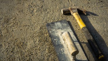 Paslı metal çekiç ve doğal ışık ve gölgeli grunge çimento zemin üzerinde son mala yatıyordu. Boş kopya alanı olan çalışma günü konsepti.