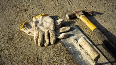 Paslı metal çekicin düz yatışı, bitiş malası ve inşaat beyaz eldiven grunge çimento arka planda doğal ışık ve gölge ile. Boş kopya alanı olan çalışma günü konsepti.