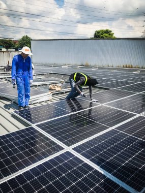 Nilai, Malezya - 1 Haziran 2020: Güneş paneli teknisyeni. Yenilenebilir enerji. Açık alana fotovoltaik panel kurulumu.