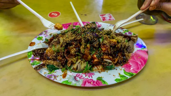 人々龍タウフーやYentafu テーブルの上にプラスチックフォークを使用して中国料理を食べる ひき肉や魚のペーストで満たされた豆腐で構成されています 画像にはノイズと選択フォーカスが含まれます — ストック写真