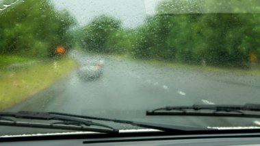 Selangor, Malezya - 31 Mayıs 2020: Yağmurlu bir günde arabanın ön camından Persiaran Mokhtar Dahari yolunun manzarası. Shah Alam Batu Arang Otoyolu. Seçici odak ve gürültü içerir.