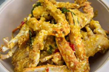 Masadaki beyaz kasede tuzlu ördek yumurtasıyla karıştırılmış tereyağlı yengecin yakın görüntüsü. Seçici odak.