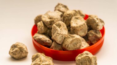 Bir yığın çiğ Asam Boi ya da beyaz arka planda kırmızı kasede ekşi erik. Genellikle atıştırmak ve içki yapmak için kullanılır..