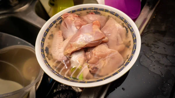 在烹调前 在厨房将生鸡片放在温水碗中解冻的近景 — 图库照片#