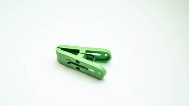 Beyaz arkaplanda izole edilmiş yeşil mandal ya da elbise askılarının yakın plan resmi.