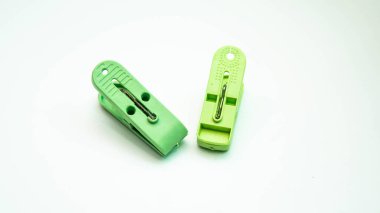 Beyaz arkaplanda izole edilmiş yeşil mandal ya da elbise askılarının yakın plan resmi.