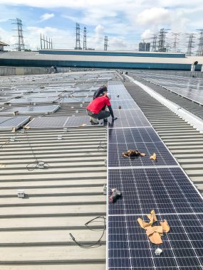 Nilai, Malezya - 1 Haziran 2020: Güneş paneli teknisyeni ve mühendisi güneş paneli kurulumu üzerinde çalışıyor. Yenilenebilir enerji. Açık alanda fotovoltaik panel kurulumu. Seçici odak.
