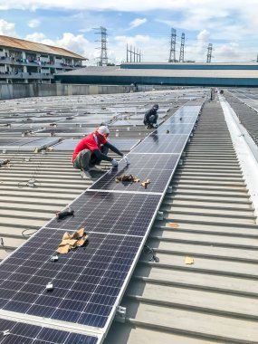 Nilai, Malezya - 1 Haziran 2020: Güneş paneli teknisyeni ve mühendisi güneş paneli kurulumu üzerinde çalışıyor. Yenilenebilir enerji. Açık alanda fotovoltaik panel kurulumu. Seçici odak.