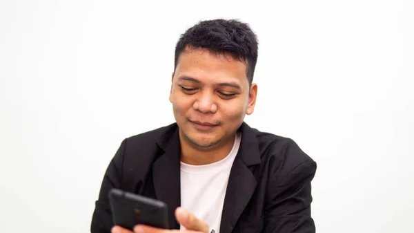 Portrett Ung Asiatisk Mann Som Smiler Mens Han Ser Smarttelefonen – stockfoto