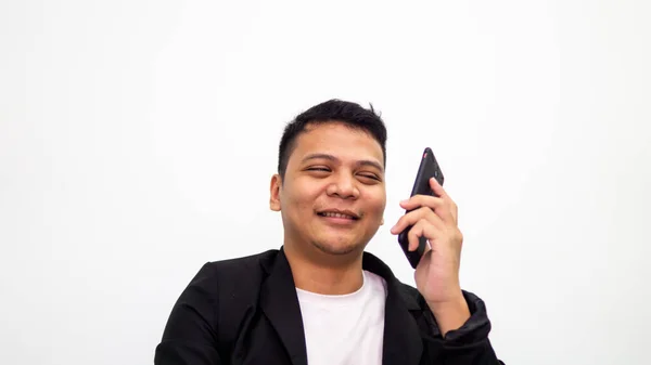 一张年轻的亚洲商人的画像 他一边笑着一边用智能手机与白人背景隔离地交谈 商业和企业家概念 — 图库照片