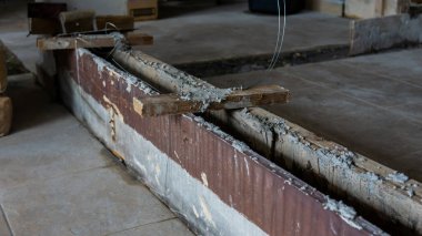 İnşaat sürecini yakından görmek bir binanın duvarını örüyor. Çerçeve olarak çimento ve ahşap tahta kullanarak beton döşeme yapın. Seçici odak.
