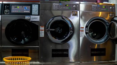 Bangi, Malezya - 28 Temmuz 2019: Bangi 'deki Teras Jenang' da Mizz Launderette 'de bir self servis madeni para makinesi işletiyordu. Seçici odaklanma. Çamaşır sepetini çamaşır makinesinin yanına koy..