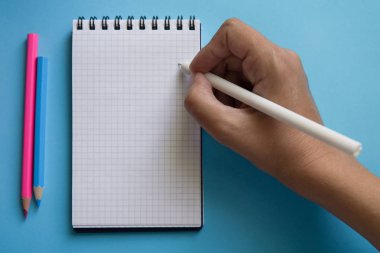 İki renkli arka planda çeşitli kırtasiye ve dizüstü bilgisayar.