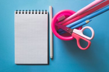 Mavi zemin üzerinde çeşitli kırtasiye ve defter.