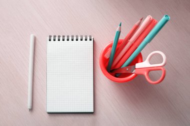 Ahşap bir masada çeşitli kırtasiye malzemeleri ve dizüstü bilgisayar.