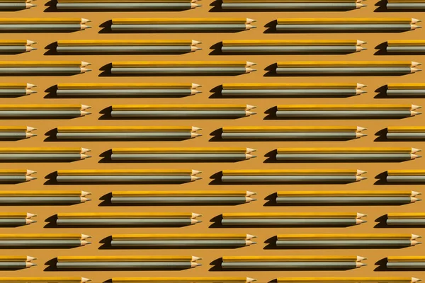 Patroon van goud en zilver potloden op gouden achtergrond. — Stockfoto