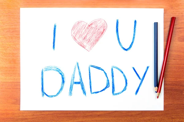 Fathers day concept. Composition with childs drawing with words I Love U Daddy and pencils.