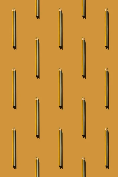 Pattern of gold and silver pencils on gold background. — Stock Photo, Image