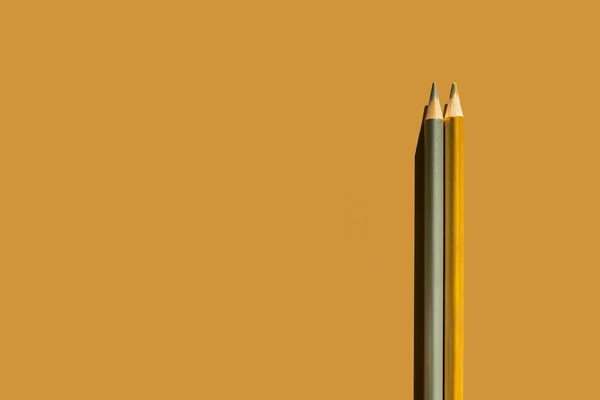 Gold and silver pencils on gold background. — Zdjęcie stockowe