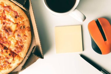 Kutuda pizza, bir fincan kahve, dizüstü bilgisayar faresi, kalem ve boş çıkartma..
