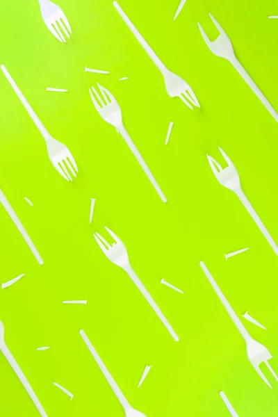 Pattern of broken plastic forks on a green background. — Stock Photo, Image