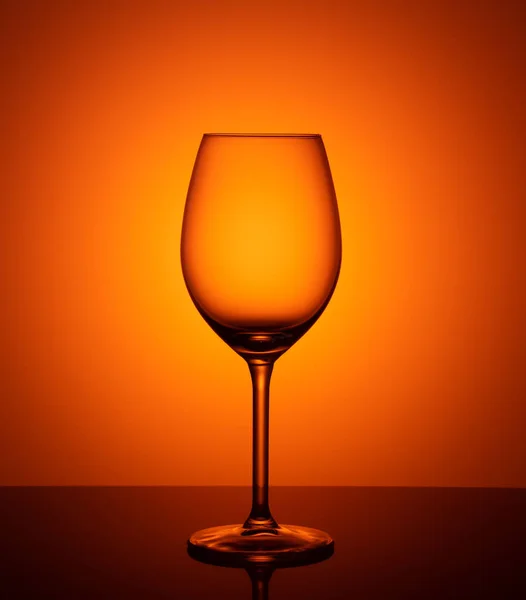 オレンジ色の背景に空のグラス ゴブレット — ストック写真