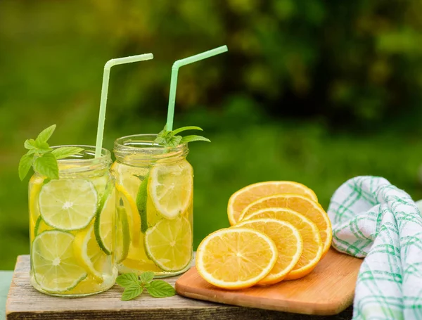 Bebida casera de limón y lima. El proceso de cocinar limonada al aire libre —  Fotos de Stock